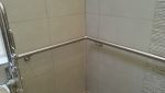 STAINLESS STEEL HANDRAIL FORMED TO FIT A CORNER OF THE BATHROOM